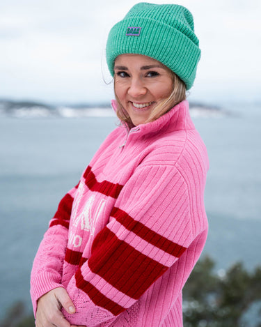 Bilde av Helene fra siden med ANN half zip i rosa og DRYSS lue i grønn.