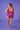 Bilde tatt av den mønstrede rosa badedrakten fra baksiden. Personen står foran en lilla bakgrunn.