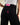 Nærbilde av jeansen fra baksiden. DAAE Studio-logoen i rosa og rød er synlig på baksiden.